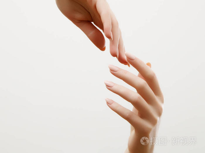 光修指甲指甲上的美丽的女人双手的特写.奶油的手和治疗