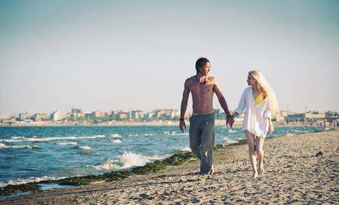 浪漫情侣在海滩上走在一起