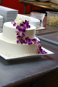 紫色兰花的白色婚礼蛋糕