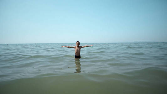 快乐的男孩从海水中走出来。前电影稳定视图