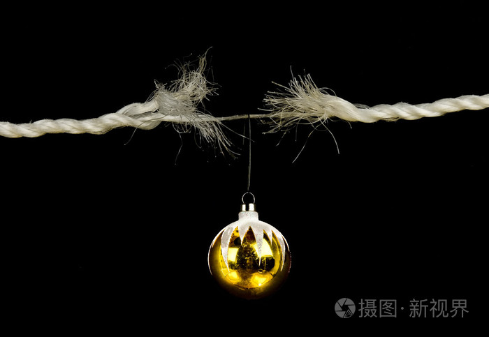 磨损的绳子与孤立在黑色背景上的圣诞灯泡假日应力概念