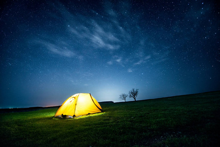 星光灿烂的天空下, 夜晚群山中闪耀的露营帐篷