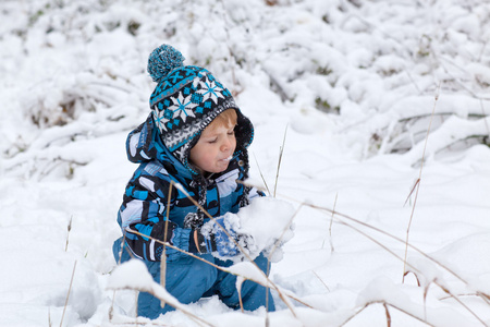 可爱的小孩男孩在冬季一天玩雪