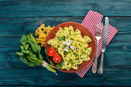 意大利面配菠菜和蓝干酪。在一个木质的背景。顶部视图。复制空间