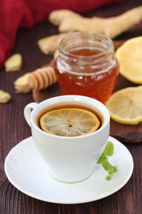 一杯姜汁茶, 加蜂蜜和柠檬在木桌上。医疗。排毒饮料