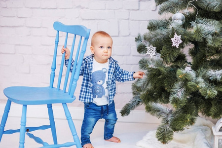 可爱的小男孩在圣诞树附近