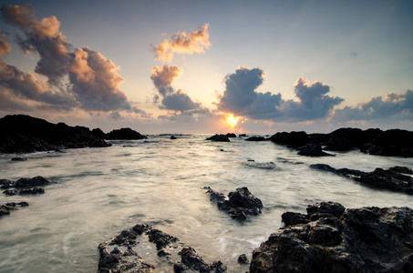 美丽的海景和魔力的光线的达克海滩位于瓜拉丁加奴，马来西亚在日出期间用流过岩石的波浪