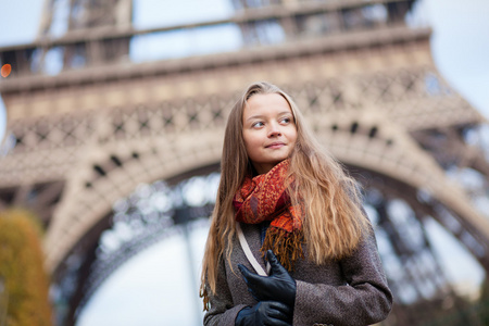 美丽的年轻女孩在巴黎埃菲尔铁塔附近