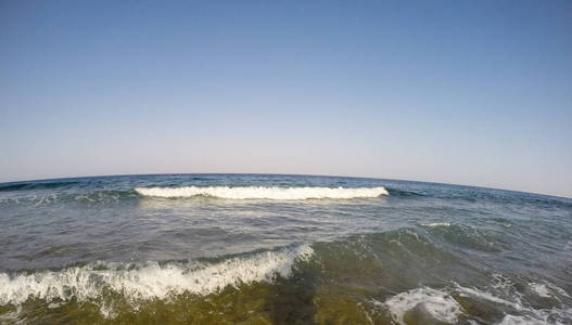 蓝天背景下海岸线上的海浪