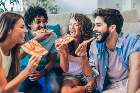 一群年轻的朋友吃比萨饼。家庭聚会