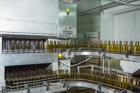 未标记的玻璃瓶，在装瓶机在现代酿酒厂