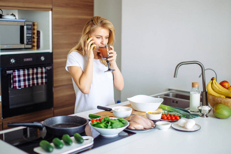 家庭厨房的妇女做健康膳食和读信息在电话里