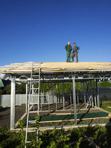 白种人执行屋顶工作。木制板条的安装