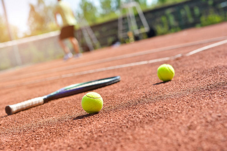 近距离的网球拍和球在红土网球场上的视图