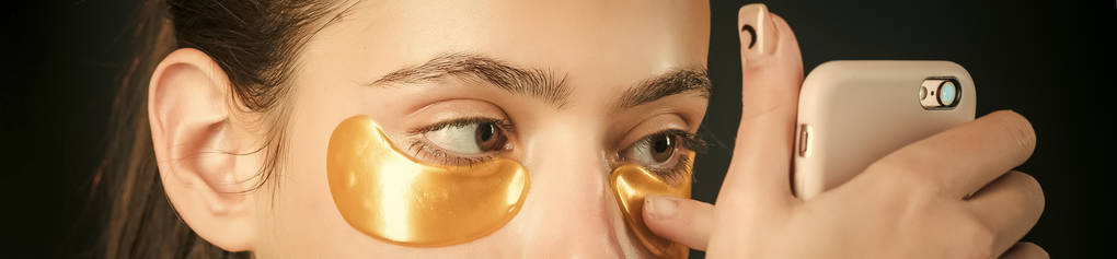 皮肤护理。眼睛下的胶原蛋白面膜从皱纹中金色