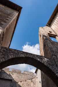 蓝色天空背景的中世纪城堡拱门竖向低角观