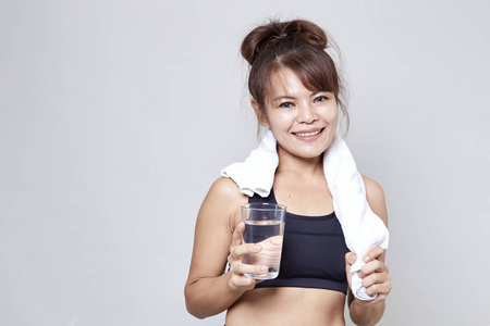 锻炼亚洲妇女饮用水在她的脖子在白色背景附近拿着白色毛巾
