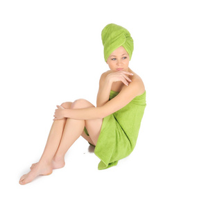 水疗中心的女孩。用绿色毛巾沐浴后美丽的年轻女子。在白色隔离