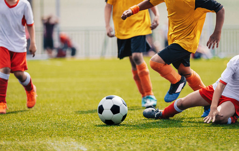 年轻的初中足球比赛。球员奔跑和踢足球球