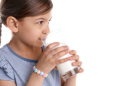 在白色背景下喝牛奶的可爱的小女孩