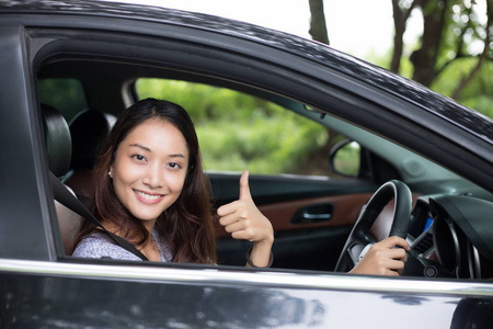 美丽的亚洲女人微笑，enjoying.driving 旅行路上一辆车