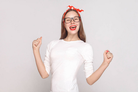 白色 t恤和眼镜上的快乐年轻女子肖像在浅灰色背景下