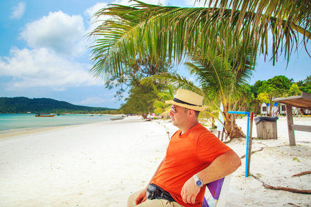 在海滩上放松的太阳镜和帽子的游客