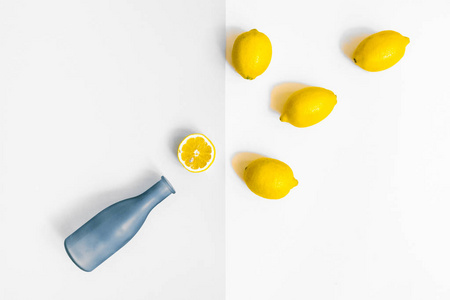 水瓶和一些柠檬在柔和的灰色和白色背景。平躺, 顶部视图