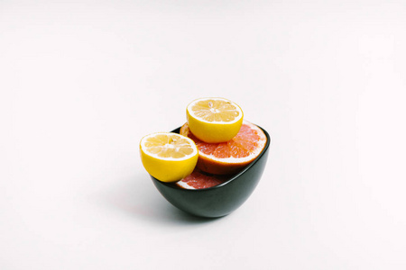 水果背景。五颜六色的新鲜柠檬和葡萄柚在白色桌上的黑盘子。平躺, 顶部视图