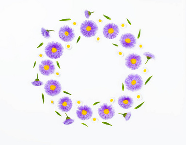花花环由紫罗兰色花和洋甘菊在白色背景。平躺。具有复制空间的顶部视图