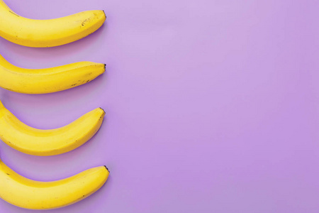 四香蕉边界框架在紫色霓虹紫罗兰色背景。文本的空白。简约理念