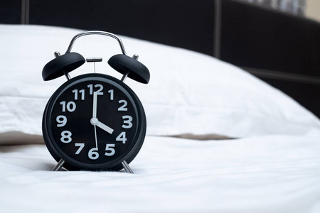 老式闹钟在卧室的床上, 起床或睡觉时间概念观念