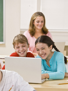 女孩在教室里使用便携式计算机