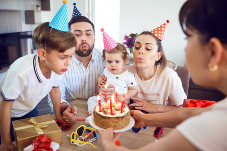 一个快乐的家庭用蜡烛蛋糕庆祝生日聚会
