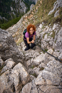 妇女自由攀登在一个通过 ferrata 在落基山脉