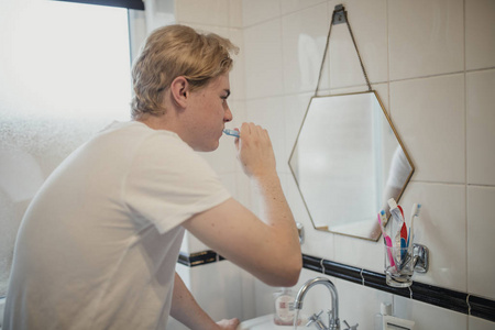 年轻的成年男性在早上例行刷牙