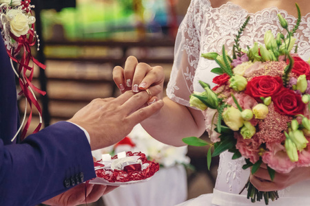 新娘和新郎在夏季花园的婚礼仪式上交换戒指。新娘手捧着一束结婚花束