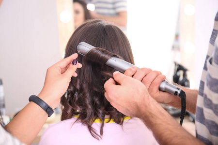 专业美发师和实习生在沙龙与客户合作。学徒理念