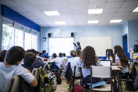 学生们在课堂上用她的平板电脑和她的同班同学一起学习, 而他们听老师讲课。