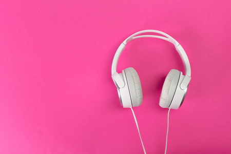 在明亮的粉红色背景上的现代耳机