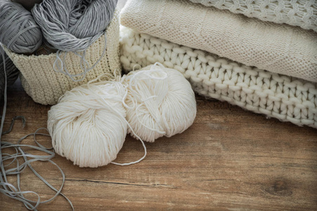 针织和针织针用白色和灰色线编织的篮子。针织特写的白色毛衣和纱线。冬天