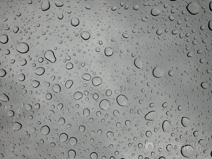 窗玻璃上的雨滴雨落在多云背景下的雨滴背景自然模式