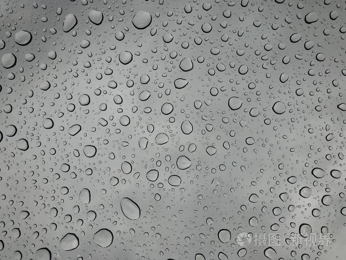 窗玻璃上的雨滴雨落在多云背景下的雨滴背景自然模式