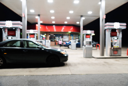 模糊关闭加油站与汽车加油在晚上在美国阿肯色州。弥散, 在黄昏时分, 出了重点加油站和便利店。抽象模糊加油站背景