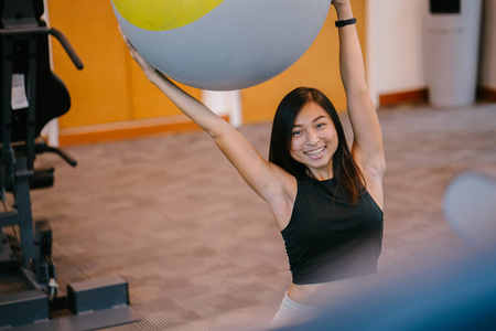 健身, 运动, 训练和人的概念微笑的亚洲妇女在健身房锻炼球