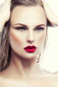 白色背景下的自然妆和红唇的年轻女子肖像