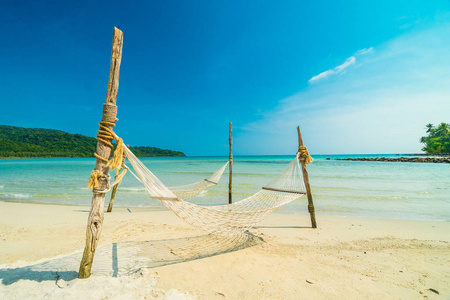 在美丽的热带海滩上的吊床与椰子树和海背景