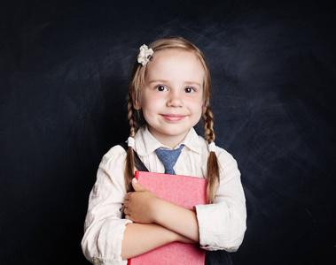 带着书微笑的孩子。在学校的小女孩统一的肖像。回到学校, 阅读和教育理念
