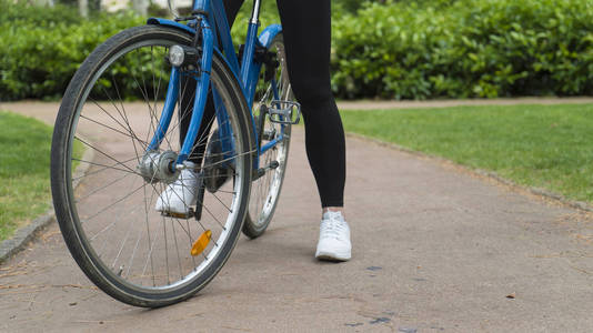 女孩骑自行车在城市公园关闭