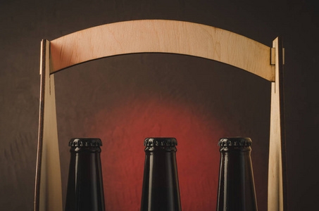 啤酒瓶的颈部在一个木盒颈部的啤酒瓶在一个木箱上的红色 tslet 背景。选择性聚焦